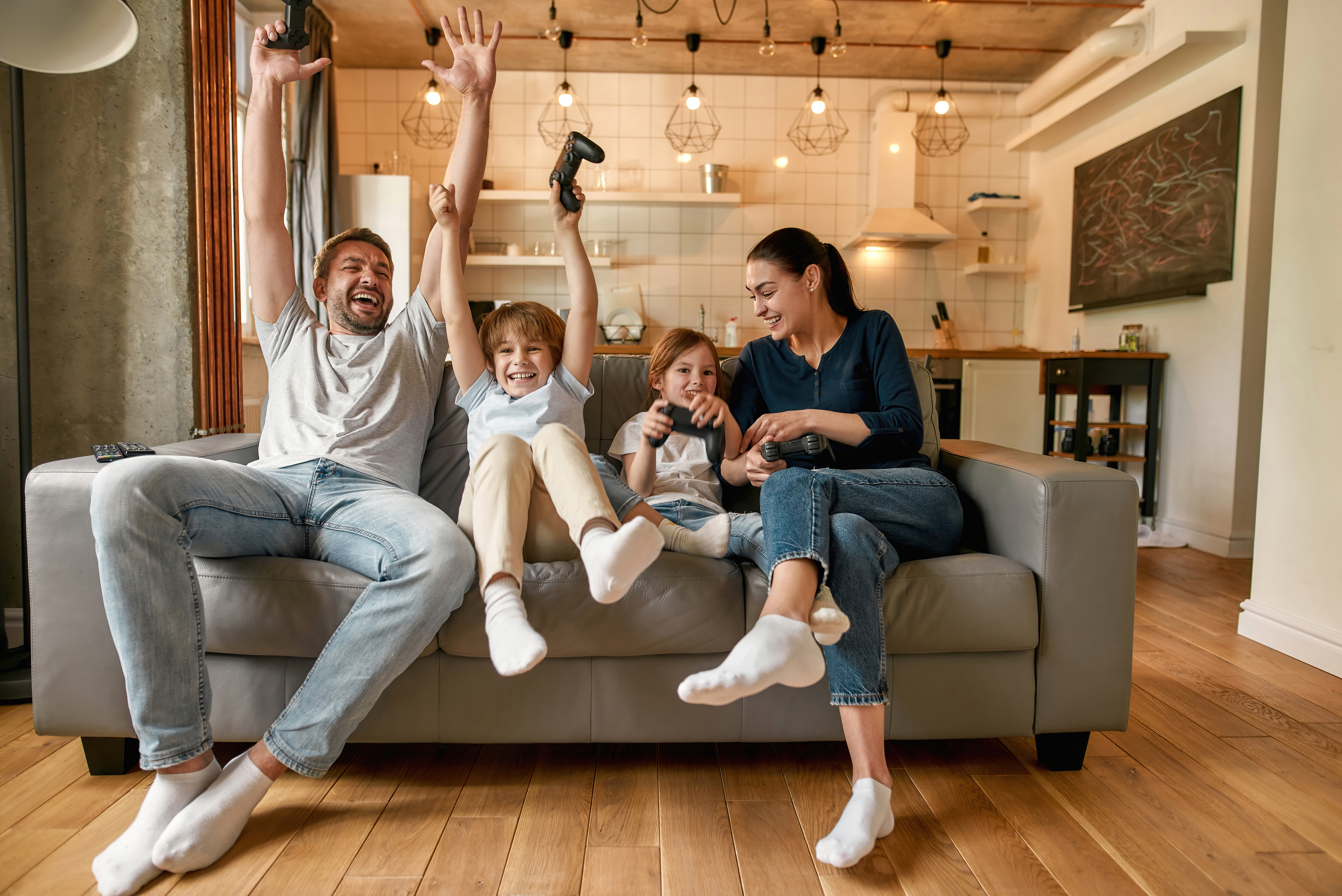 A family cheering together while playing video games in their living room